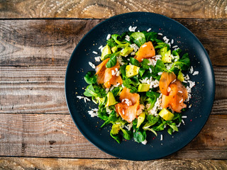 Salmon salad - smoked salmon white rice and vegetables on wooden table