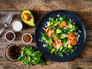 Salmon salad - smoked salmon white rice and vegetables on wooden table