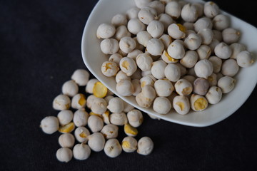White roasted chickpeas in a bowl and poured in front of it.