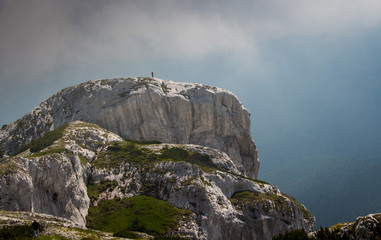 Hiker man standing on a cliff in Retezat National park in Carpathian mountain range, Romania