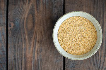 Canadian flax-seeds in bowl on wooden background. Top view