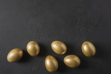 Chicken golden eggs on black. Easter dark concept. View from above.