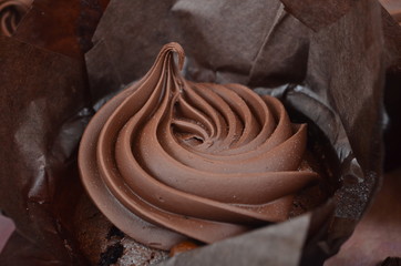 THREE  CHOCOLATE MUFFINS WITH CHOCOLATE CREAM ON PAPER BASKET