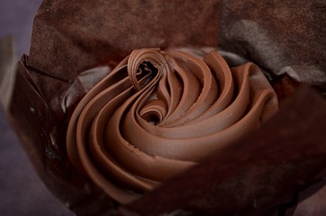 THREE  CHOCOLATE MUFFINS WITH CHOCOLATE CREAM ON PAPER BASKET