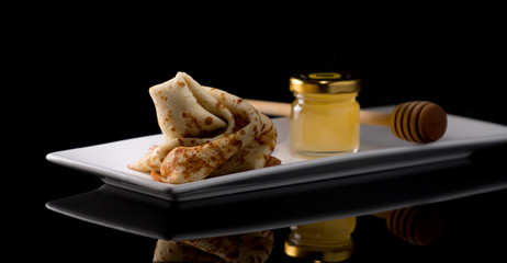 Shrovetide Maslenitsa Butter Week festival meal. Stack of russian pancake blini on a dark rustic wooden background. Front view with copy space