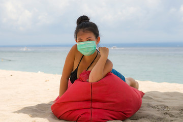 young attractive Asian Korean woman enjoying beach holidays wearing bikini and protective facial...