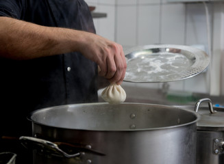 Chef coocking georgian khinkali or japanese wonton. Traditional meal 