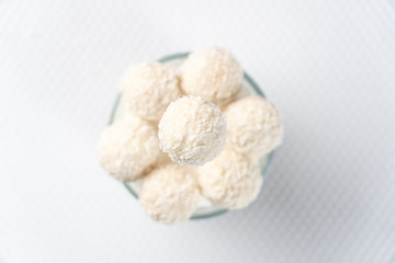 Candies in coconut flakes round coconut sweets with blurry white background light, collection, bowl, eat, elegant, Candies, sweets, blurry, glass, cup