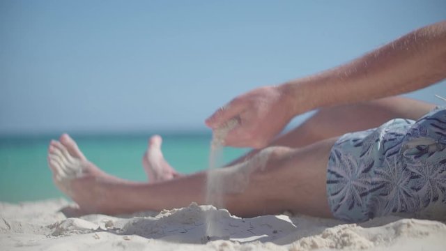 Hand Playing With Sand On Bahamas Vacation Holiday.Guy Relaxing On Tropical Beach.Happy Calm Healthy Young Man Resting On Ocean.Man Pouring Sand Through Fingers.Guy Sitting On Beach Caribbean Coast
