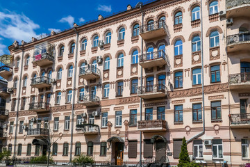 A red building with many ornate decors on the front facade. The building has many small windows and balconies. Very detailed construction.