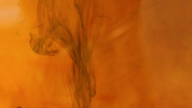 Blurred motion orange colors are melting in water to be texture background. Abstract form of color in water, isolated on white background