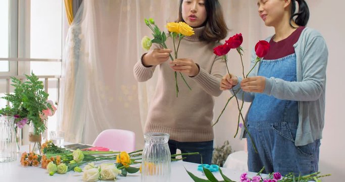 4k,chinese young girl florist is training her friend how to make a beautiful bouquet, she  telling her to pick different flowers and colors as collocation,in chengdu china