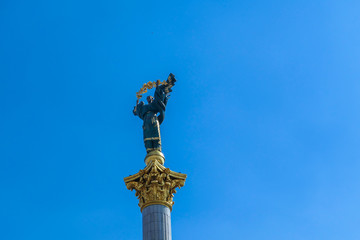 A close-up on Statue of Berehynia, located at the top of victory column on Maidan Nezalezhnosti (Independence Square) in Kiev. A woman is holding  golden branch. Clear and blue sky.