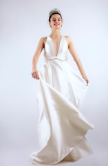 Fototapeta na wymiar Portrait of a beautiful girl in a wedding dress. Dancing Bride, gray background. Isolated