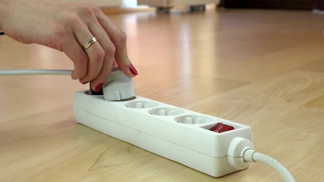female hand put the different plug in an extension cord. 4K