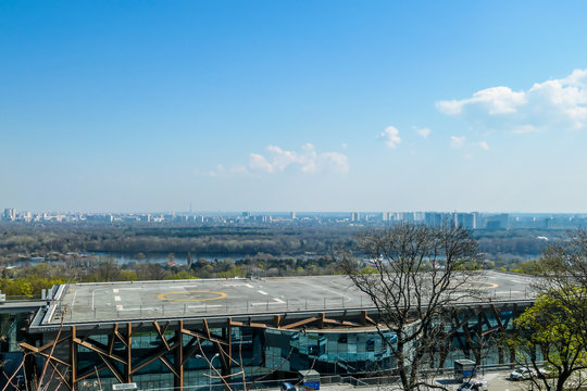 A helicopter landing on top of a hospital in Kiev, located next to the Dnieper river. Picture taken from above, with great panoramic view of the city.