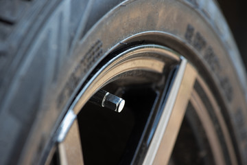 metal tyre valve on car wheel.
