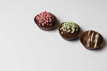 Chocolate Potato Cake. Some decorated with sprinkles, others with chocolate. On white background.