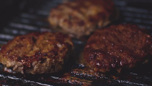 BBQ Grilled batch of ground beef patties or frikadeller Burgers Patties On Grill with smoke and burger juice sauce roasting, Top View. Cookout Food, Good Snack Nice fast food.