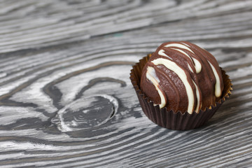 Chocolate Potato Cake. Garnished with trickles of chocolate. Against the background of brushed boards.