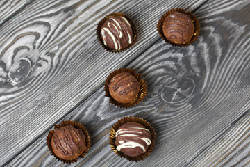 Chocolate Potato Cake. Some decorated with sprinkles, others with chocolate. Against the background of brushed boards.
