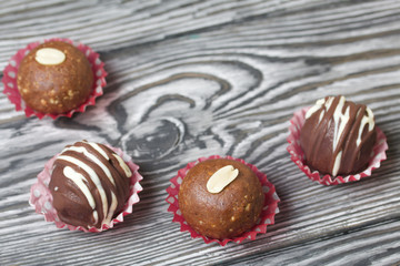 Chocolate Potato Cake. Some decorated with sprinkles, others with chocolate. Against the background of brushed boards.