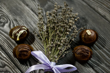 Obraz na płótnie Canvas Chocolate Potato Cake. Garnished with walnut, trickles of chocolate or sprinkled. Near a bouquet of lavender. Against the background of brushed boards.