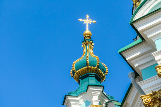 Close up on the tower of St Andrew's Church, Kiev, Ukraine. The church is small and painted blue and white with many decorations on it's facade. Picture taken from under the church. Clear and blue sky