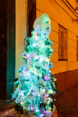 Christmas tree icicle, glowing lights, city.