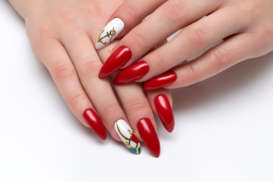 Red manicure on sharp long nails with painted anchors and umbrella on a white background. Marine manicure.