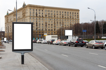 Three billboards along the edge of the road in the historic center of the city.