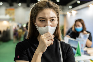 woman wearing protection mask standing in exhibition and be congested with virus infection and...