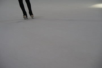 Glides on the ice. A woman slides on the ice.