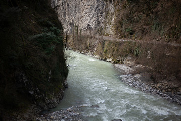 A mountain river flows over stones. The rapid flow of water. Natural background. The speed of...