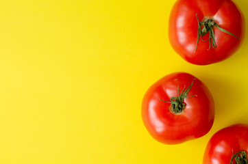 organic tomatoes on yellow background with copy space. Top view.