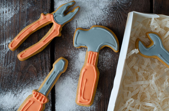 Gingerbread tool kit and icing sugar on wooden background. Top view.