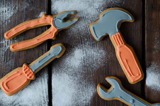 Gingerbread tool kit and icing sugar on wooden background. Top view.