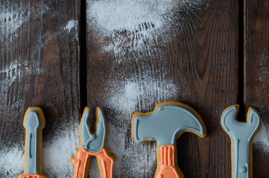 Gingerbread tool kit and icing sugar on wooden background with copy space. Top view.