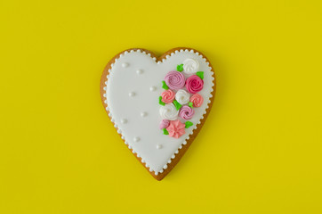 Gingerbread heart on yellow background. Top view. Ginger biscuit.