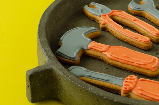 Gingerbread tool kit on concrete dish on yellow background. Ginger biscuits.