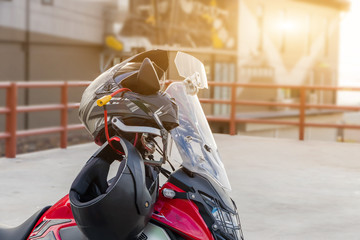 Motorcycle gloves and safety helmet hanging on a front seat of sport motorbike for safety