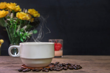 A cup of hot espresso coffee mugs and roasted coffee beans placed on wooden floor background,coffee morning,selective focus