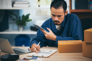 Young man entrepreneur selling online product sitting smile happily in him workplace.