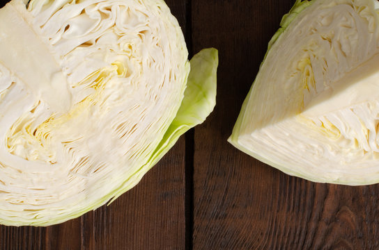 Cut organic cabbage-head on wooden background. Top view.