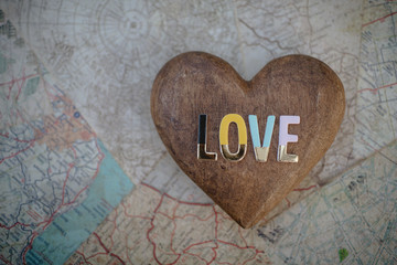 The word LOVE on a wooden heart and map