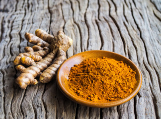 Fresh turmeric and powder turmeric on old wood background,Herbal