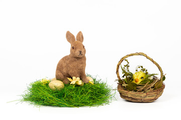 Easter concept - bunny on the nest with eggs and chicken in basket isolated on white background. Postcard studio shoot