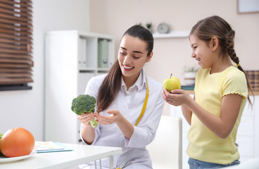 Little girl visiting professional nutritionist in office