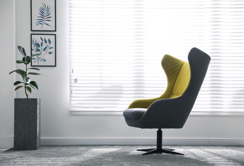 Comfortable armchair near window in light room