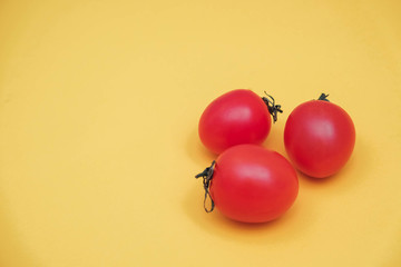 Red tomatos vegetable on a yellow background. Top view. Minimalist Style. Copy, empty space for text